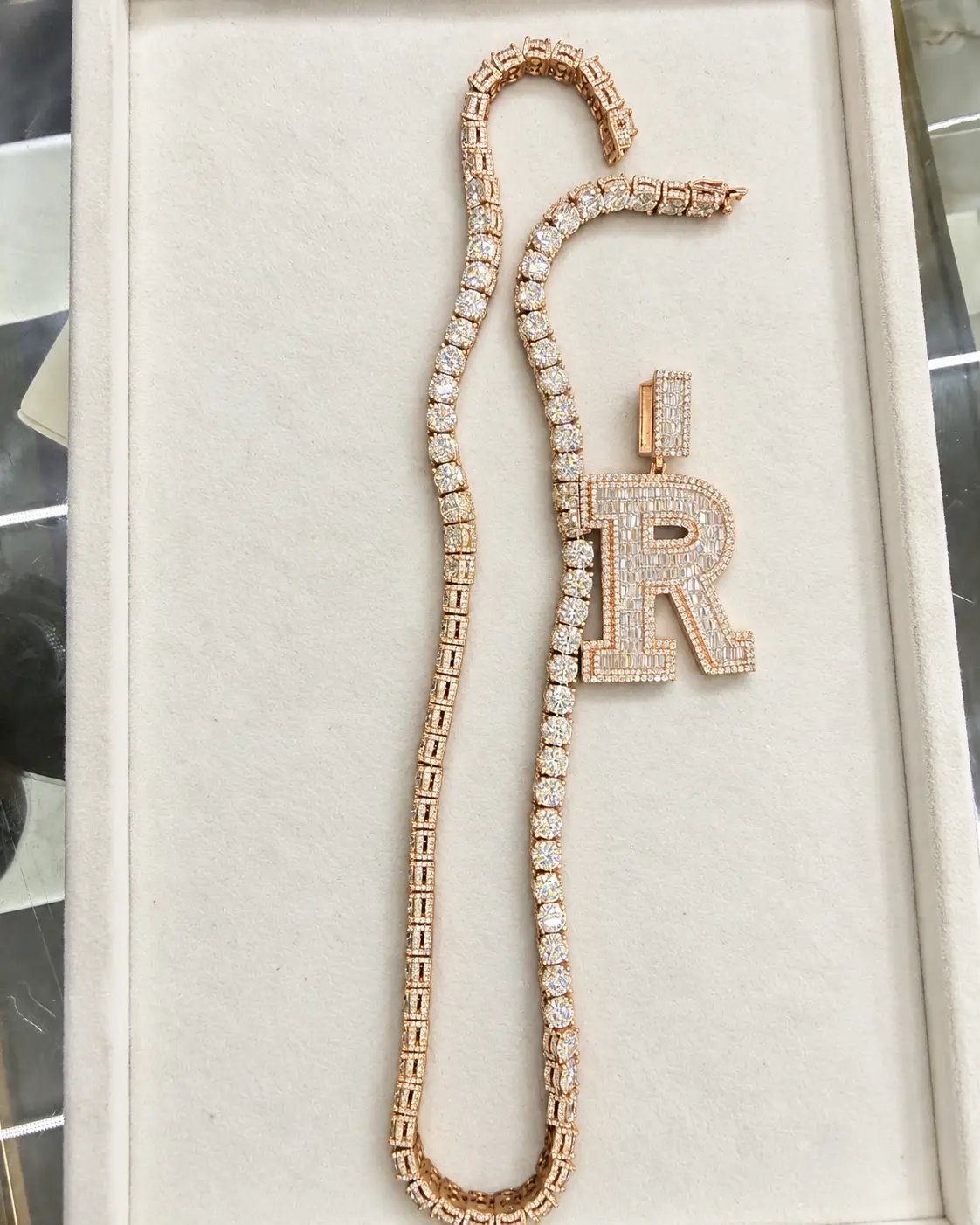 Diamond chain with an iced letter pendant in a presentation tray