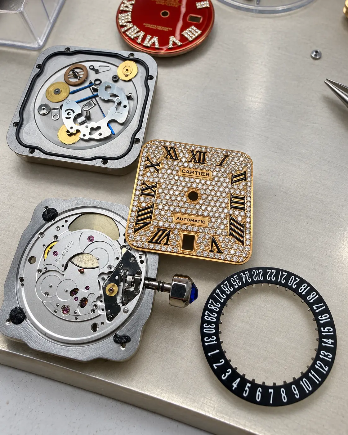 Diamond-pavé dial, movement and date wheel separated for service