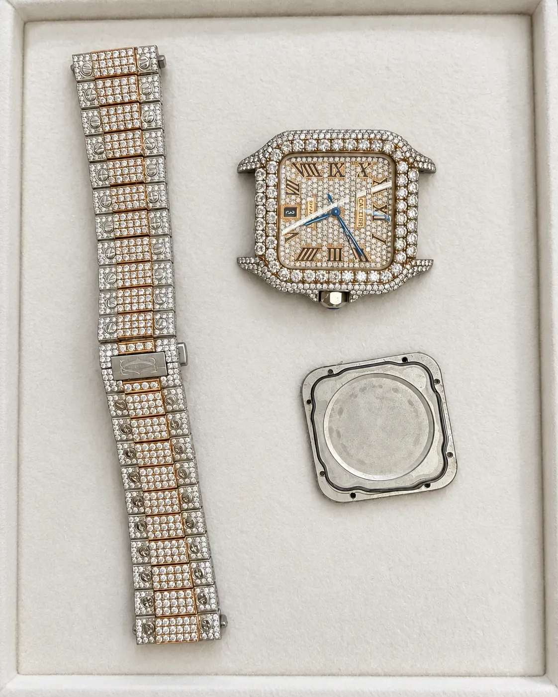 Square diamond-set watch head, bracelet and caseback in a service tray
