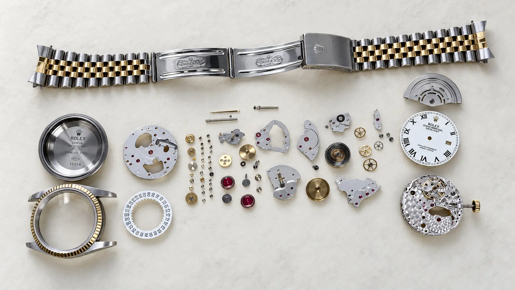 Two-tone watch taken apart with every part laid out