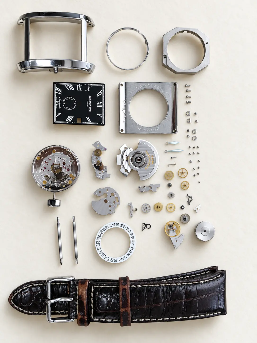 Rectangular watch fully disassembled — case, dial, movement, gears, screws and strap laid out