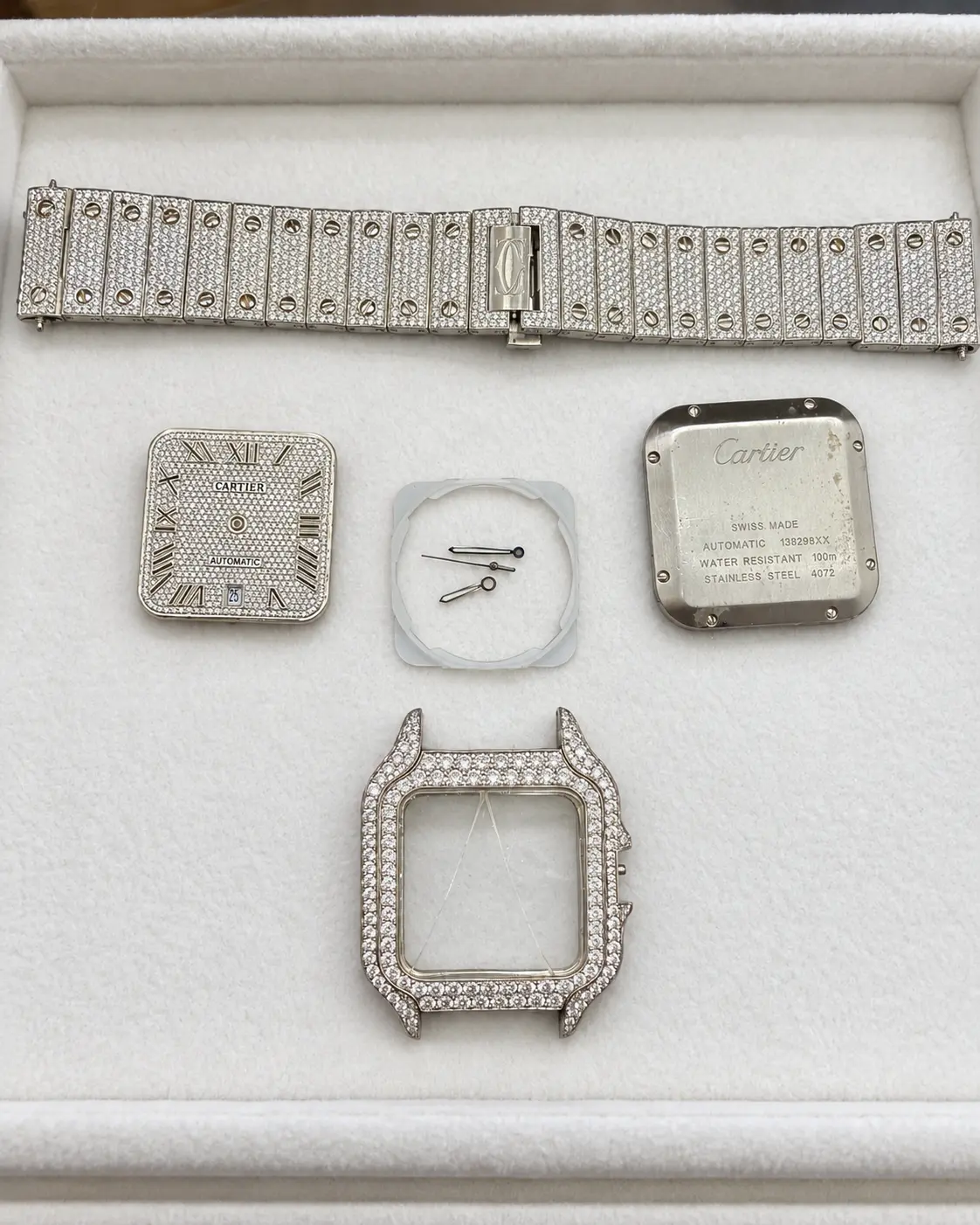 Diamond-set square watch fully separated in a service tray